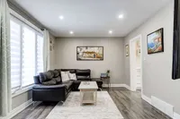 Bright living room with a leather sectional sofa and large window