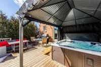 Backyard deck with a covered hot tub and gas barbecue