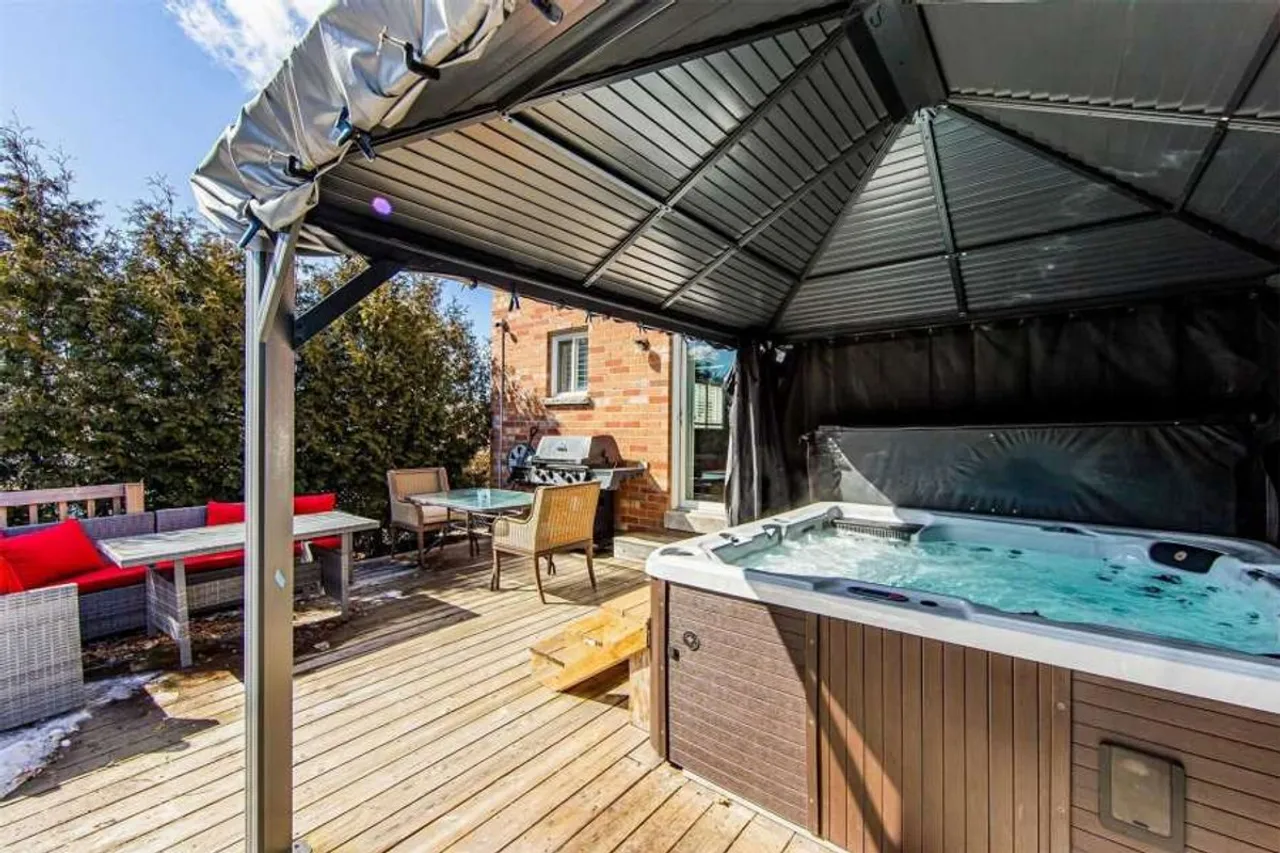 Backyard deck with a covered hot tub and gas barbecue