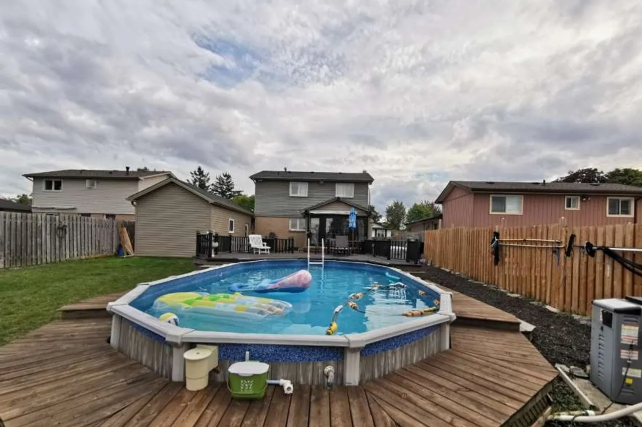 Backyard pool deck with a storage shed and mature trees
