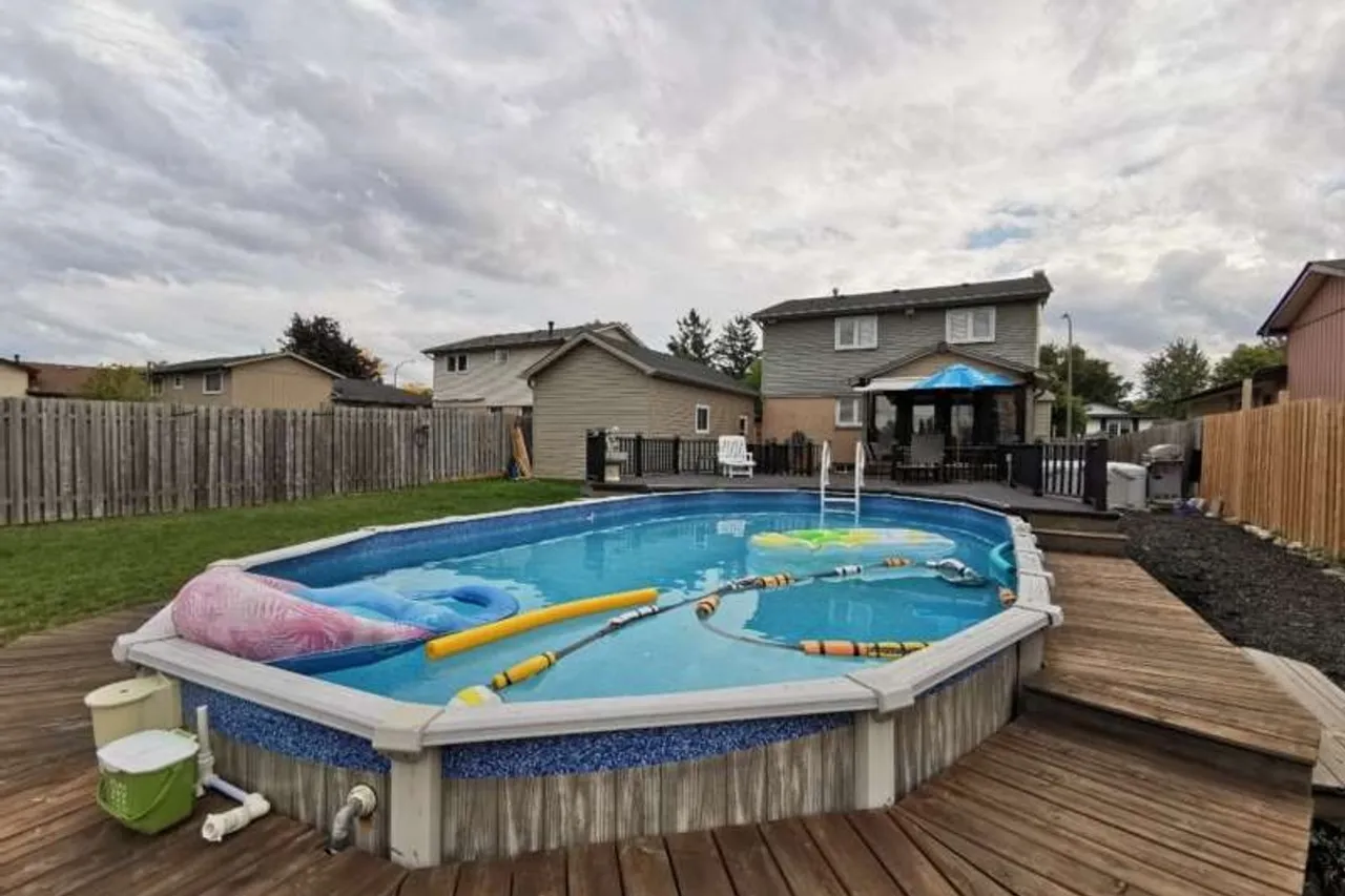 Backyard with an above-ground heated pool and deck