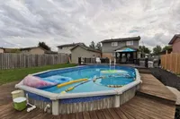 Backyard with an above-ground heated pool and deck