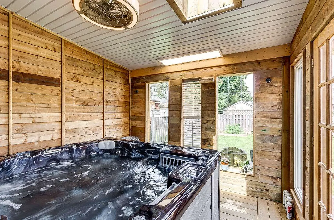 Enclosed hot tub room with skylights and a walkout to the backyard