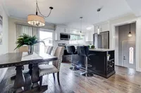Open concept kitchen island with stainless steel appliances and a separate dining nook