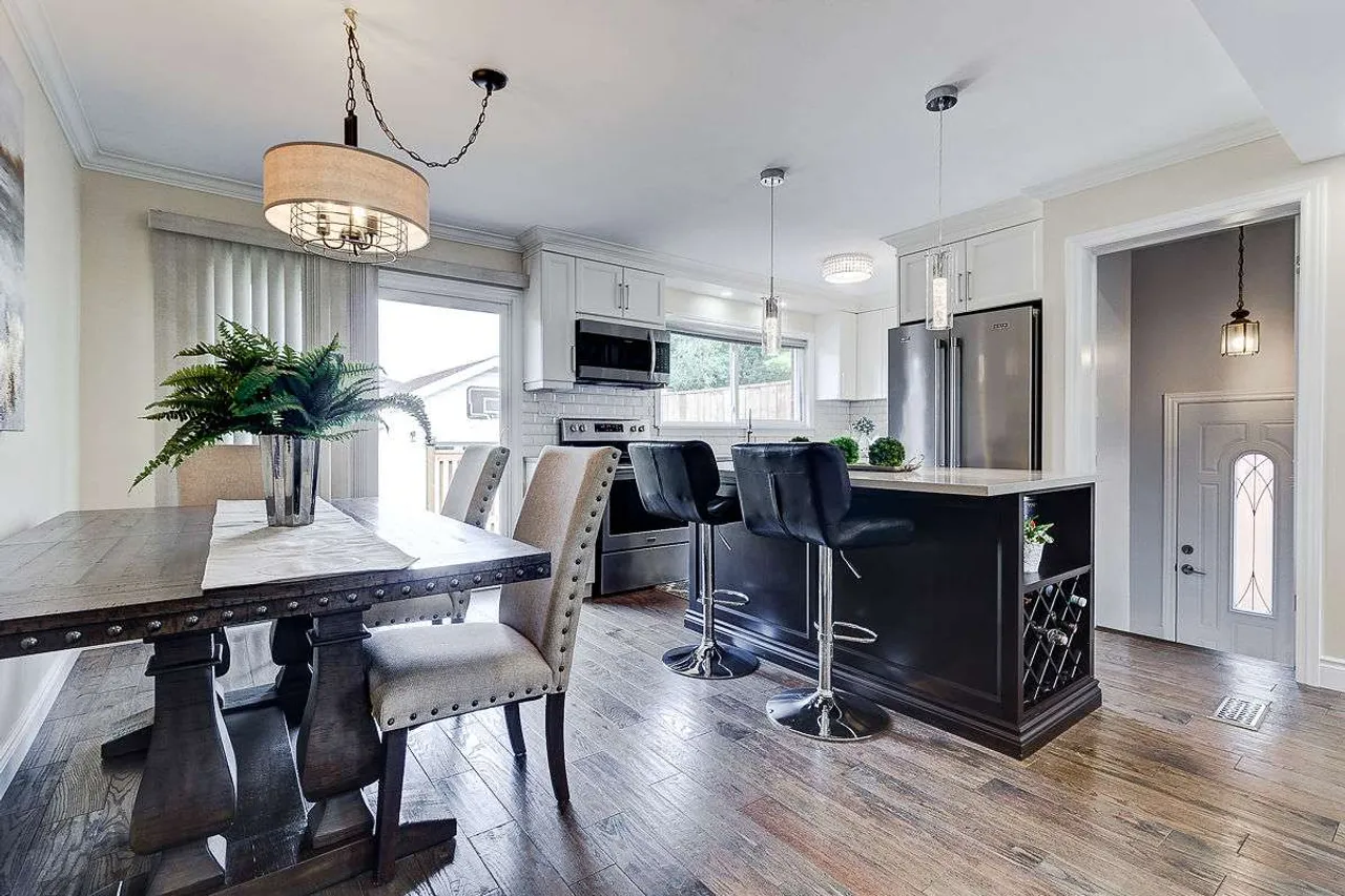Open concept kitchen island with stainless steel appliances and a separate dining nook